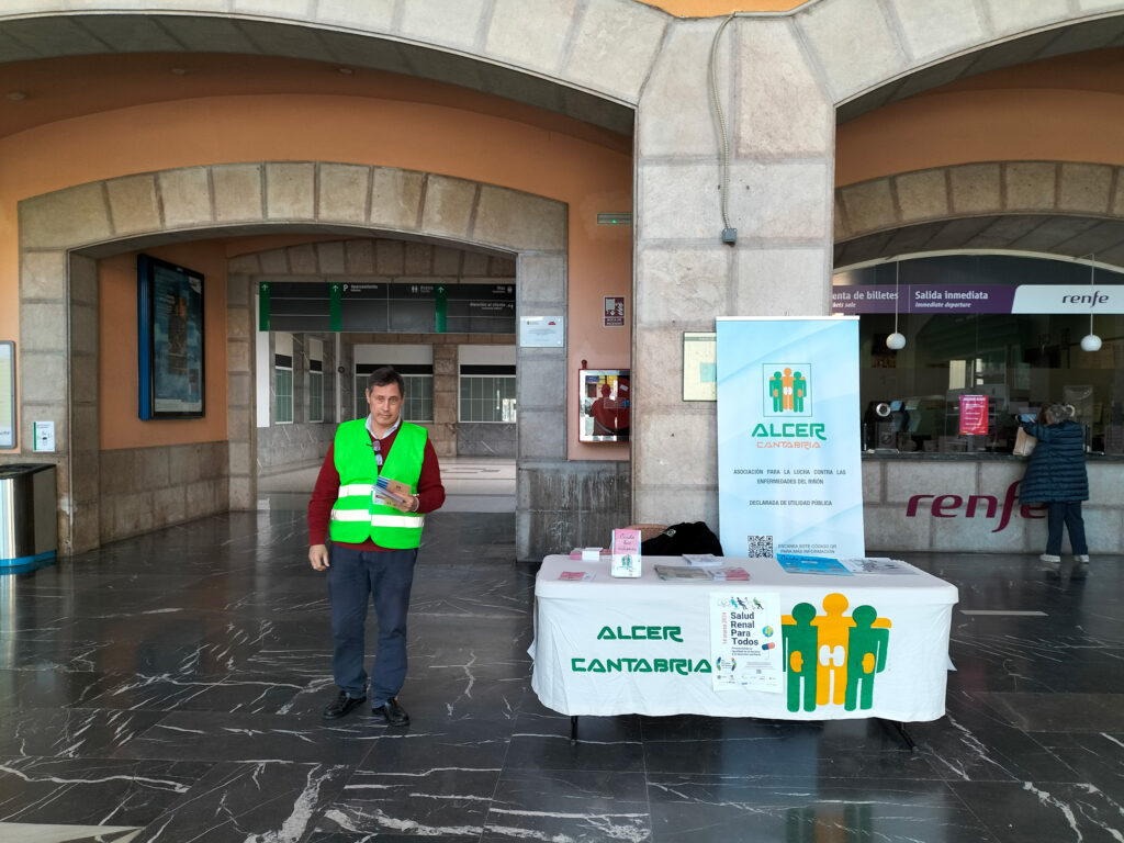 Voluntario con mesa informativa en RENFE Santander